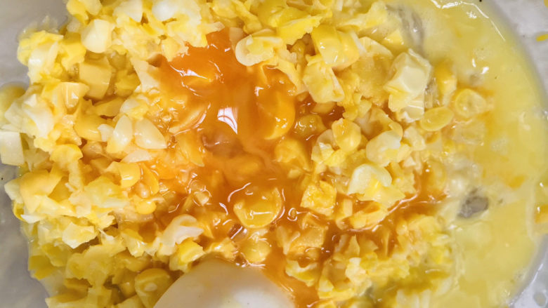 黄金玉米饼,把鸡蛋倒入装玉米的碗中