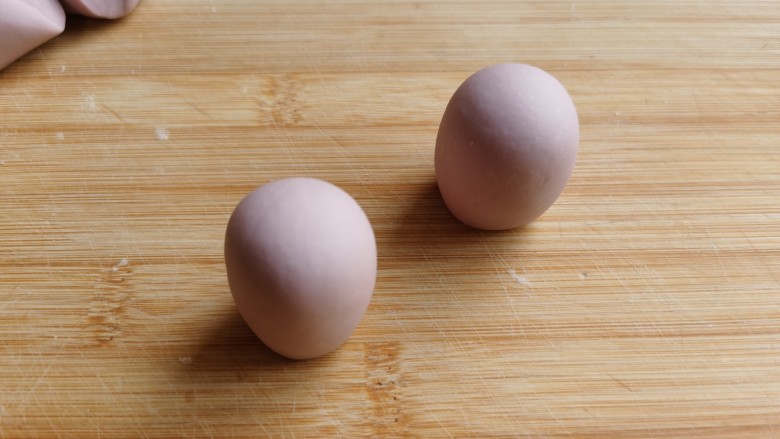 紫薯小馒头～,将每块小面团分别排气，揉成光滑的圆形，收口朝下，搓成圆形的小馒头。