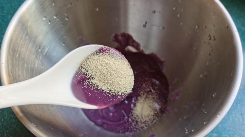 紫薯小馒头～,加入酵母粉，酵母最好先用少许水化开，再加入紫薯泥中。