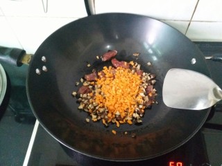 电饭煲腊肠饭,将胡萝卜和香菇放进锅里小炒片刻，放点盐