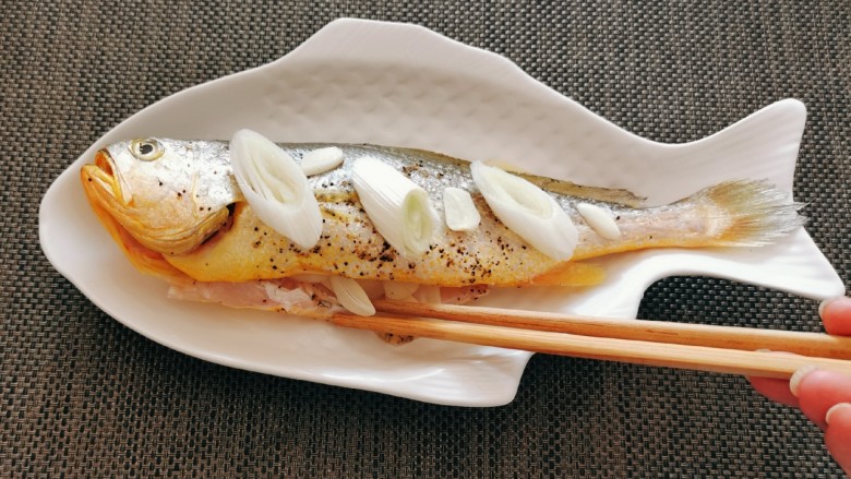 清蒸黄鱼,鱼肚、鱼身放入一部分蒜片。