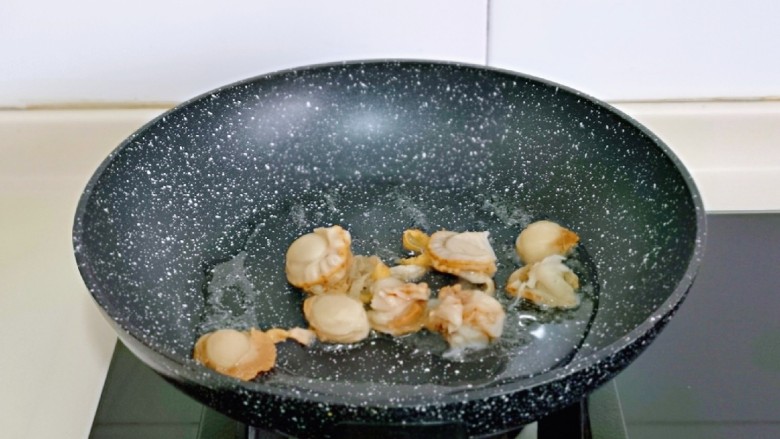 扇贝炒鸡蛋,另起油锅，加入腌制好的贝肉翻炒2分钟，盛出备用。