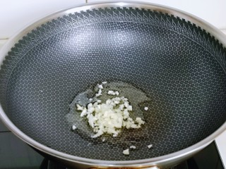 爆炒章鱼,锅中加入食用油，再加入蒜末炒香。