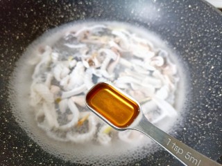 爆炒章鱼,锅水开加生姜与料酒下鱿鱼焯水。