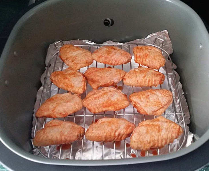 新奥尔良烤鸡翅,将腌好的鸡翅正面朝上、放至空气炸锅的高架网上