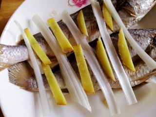 清蒸黄鱼,盘子里，鱼肚里，鱼身上分别放入葱姜。
