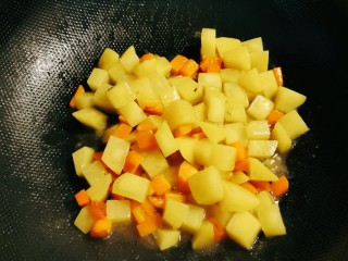 臊子面,起油锅，放入一汤匙食用油，油热后放入胡萝卜丁，土豆丁翻炒断生出锅。