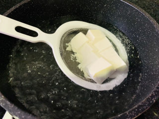 小葱拌豆腐,大火烧开水，直接把豆腐装漏勺里，放入锅中