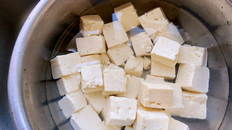 小葱拌豆腐,豆腐捞出来过凉水，煮一下豆腐的原因是，经过水煮的豆腐在凉拌的时候会结实一些，不那么容易碎。
