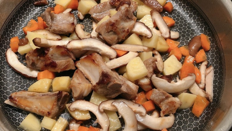 土豆排骨焖饭,加入香菇片和土豆胡萝卜丁翻炒