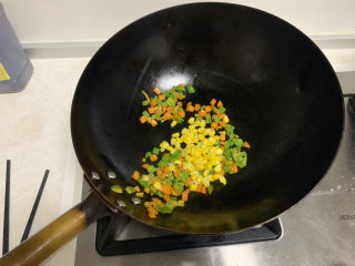 豆腐鸡蛋羹,油锅，依次放入胡萝卜、青椒、玉米粒，翻炒