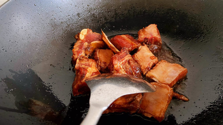 土豆排骨焖饭,加入腌渍好的排骨翻炒上色。