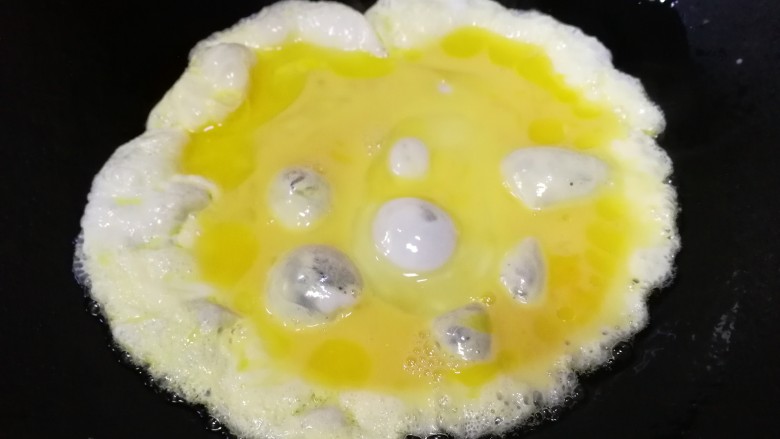 藕丁酸豆角炒鸡蛋,热锅适量油，倒入蛋液。