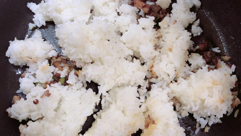 酱油蛋炒饭,倒入米饭，将米粒打散，炒均匀。