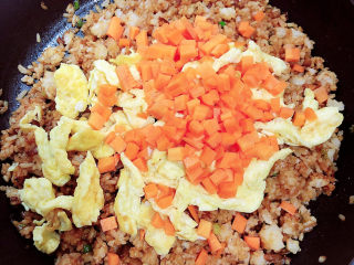 酱油蛋炒饭,放入炒好的鸡蛋和胡萝卜丁。