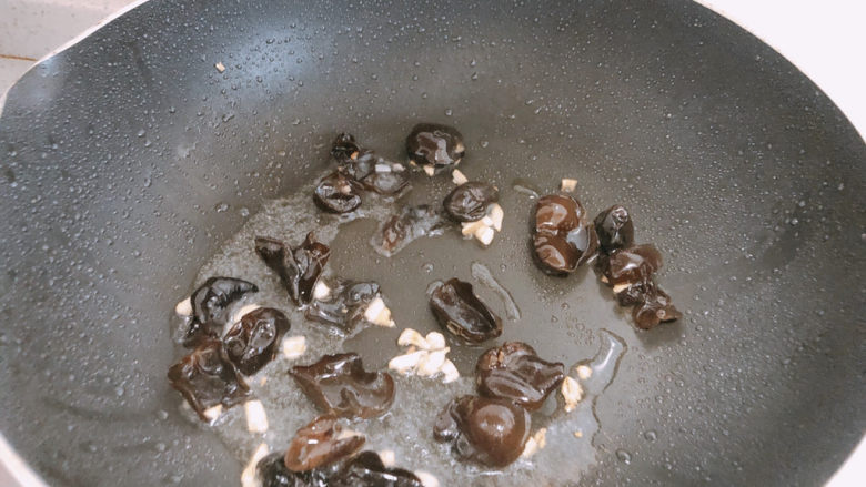 西葫芦炒木耳,锅内热油，加入蒜末爆香，加入木耳翻炒。