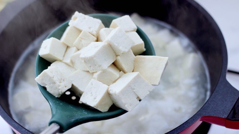 经典巨好吃的麻婆豆腐,锅中倒入适量的清水煮沸，把豆腐进行焯水，插至豆腐变软紧实的时候，捞出沥干水分。