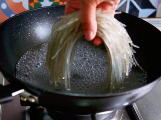 豆芽炒粉条,锅中水烧开，放入泡软的红薯粉。