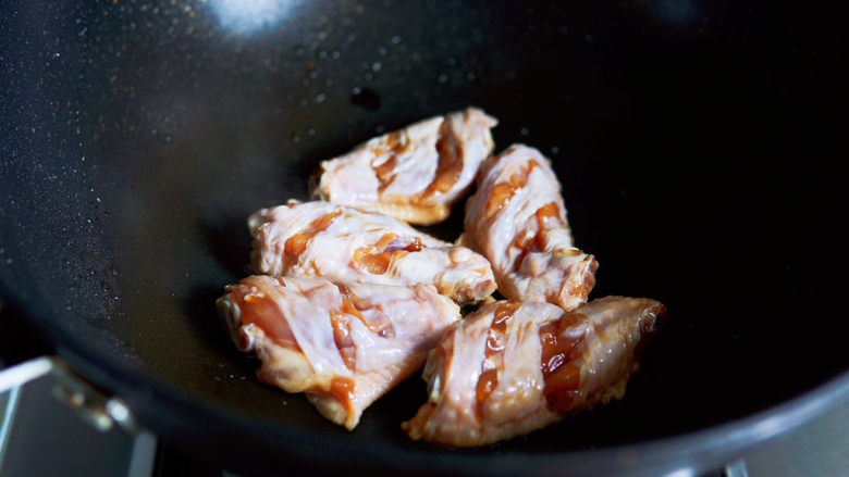 蒜香鸡翅,锅中不加一滴油，直接入锅干煎，全程用小火慢慢煎。