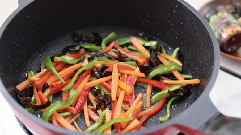 鱼香肉丝,把青红椒和胡萝卜，木耳放入炒肉条的锅中。