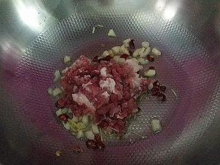 酸豆角炒肉末,锅热倒入玉米油，下葱、蒜和辣椒沫爆香，放入肉末