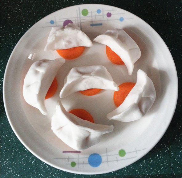 水晶蒸饺,放入盘中，在下面垫一块胡萝卜片，防粘