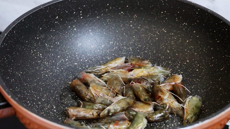 潮汕海鲜粥,锅中倒入适量的食用油烧热，放入虾头