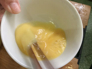 酸豆角炒鸡蛋,鸡蛋打散成鸡蛋液。