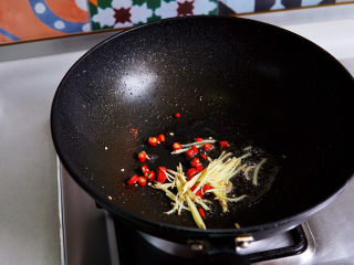 酸豆角炒肉末,锅中底油，放入红椒圈与姜丝煸炒出香味。