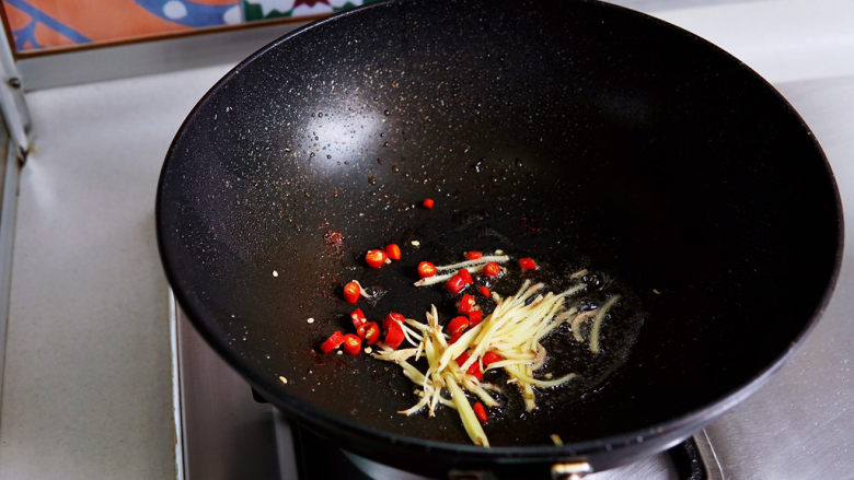 酸豆角炒肉末,锅中底油，放入红椒圈与姜丝煸炒出香味。