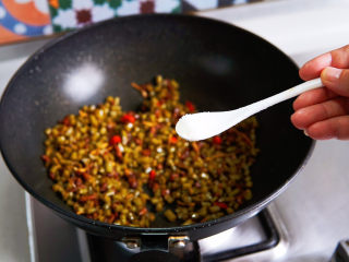 酸豆角炒肉末,出锅前加入味精，炒匀即可出锅。