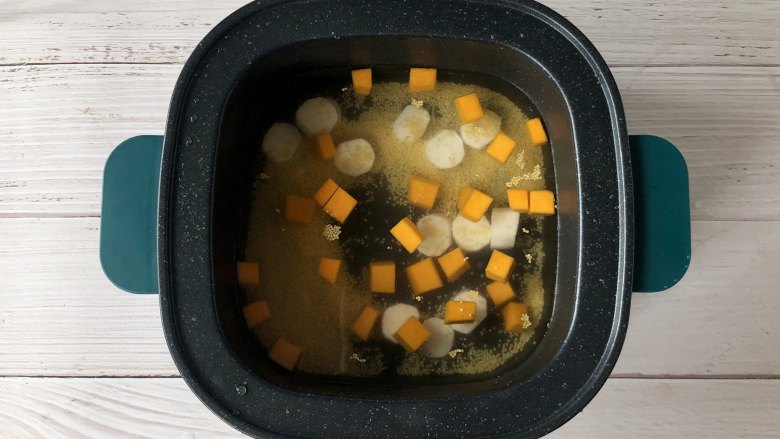 小雏菊火腿馒头卷+南瓜山药小米粥,把南瓜丁、山药丁和洗净的小米放入生活元素蒸煮锅，加入适量清水。