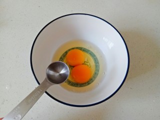 西兰花炒鸡蛋,碗中打入2个鸡蛋，加入两勺温水搅打均匀