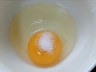 酸豆角炒鸡蛋,鸡蛋磕入碗中加入少许盐调味