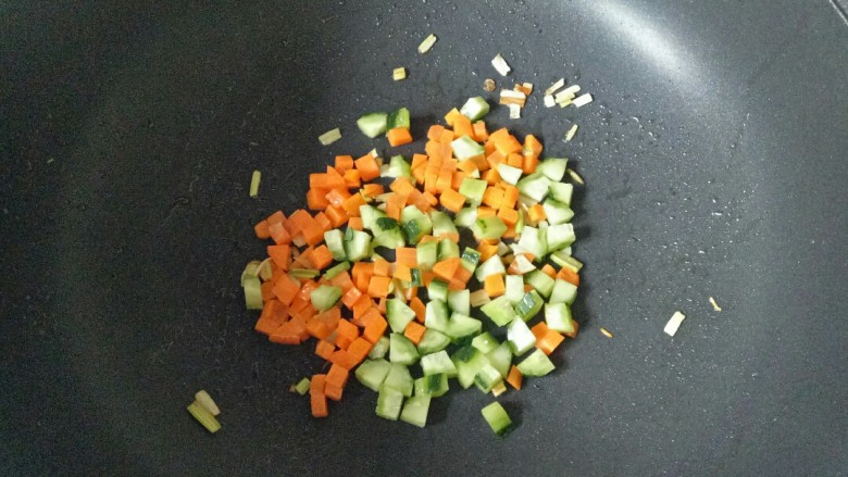青菜炒饭,加入胡萝卜丁翻炒1分钟，再加入黄瓜丁翻炒均匀