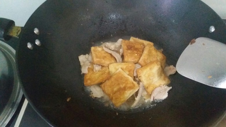 煎豆腐,放一点水，焖煮五分钟到十分钟，为的是确保豆腐熟了和入味，这里试一下盐是否够了
