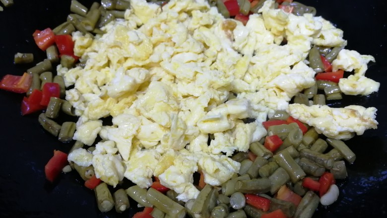 酸豆角炒鸡蛋,倒入鸡蛋，文火翻炒均匀。
