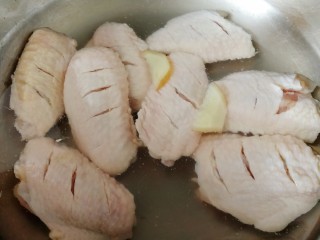 蒜香鸡翅,鸡翅凉水下锅，加生姜片，文火煮开，焯水3分钟。