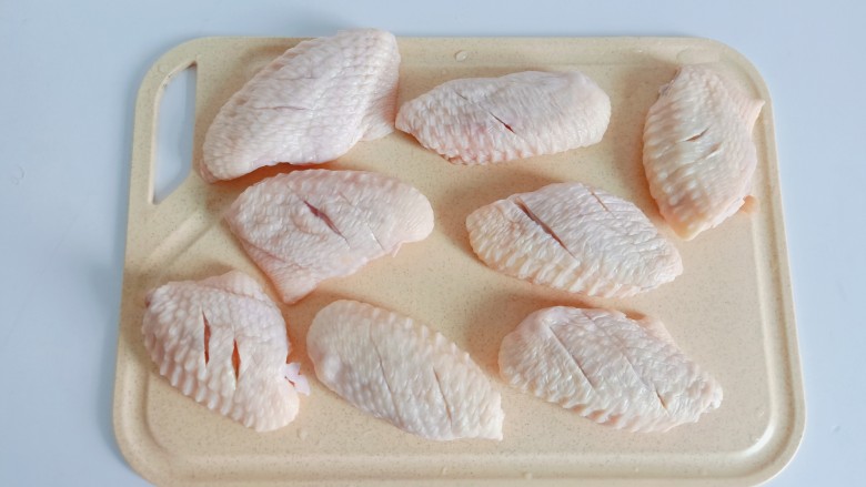 蒜香鸡翅,鸡翅正反两面各切两下，便于入味的同时在煎的时候容易熟。
