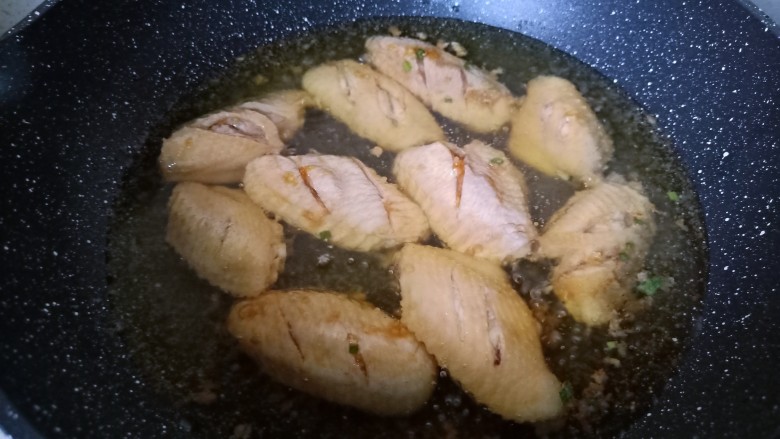 蒜香鸡翅,锅里多倒一点油，比平时炒菜的油多，中火烧热放入鸡翅。