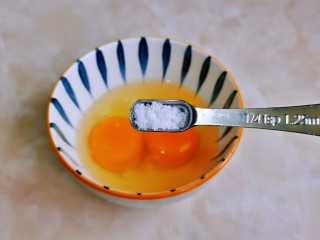 西兰花炒鸡蛋,鸡蛋磕碗里，加入盐。