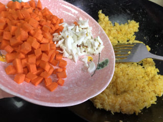 耳光炒饭,加入胡萝卜丁和咸鸭蛋白，继续翻炒。