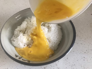耳光炒饭,剩下的两个鸡蛋打散倒入米饭里搅拌均匀备用