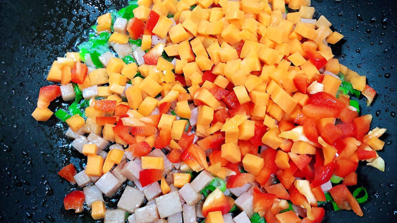 青菜炒饭,放入胡萝卜和红椒丁翻炒均匀。