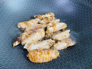 蒜香鸡翅,锅中加入少许食用油加热至五成热，放入鸡翅