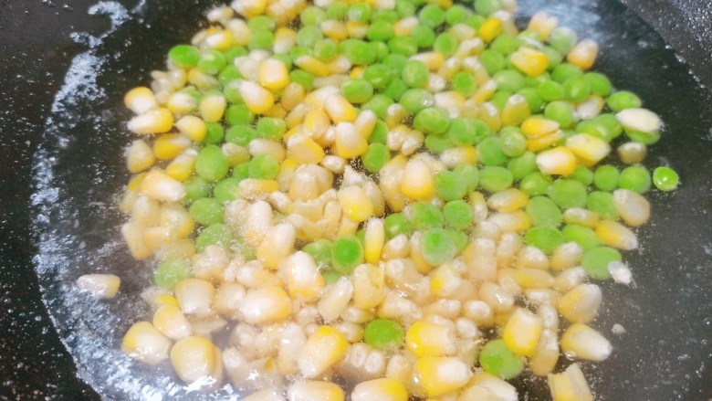 耳光炒饭,锅里烧开水，把玉米粒，豌豆倒入焯水