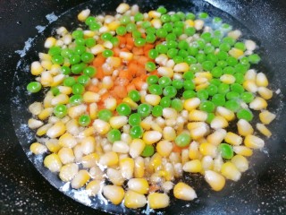 耳光炒饭,两分钟后再把红萝卜丁倒入焯水，焯至豌豆变成鲜绿色
