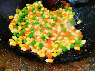 耳光炒饭,再倒入咸蛋黄，炒至冒泡，再把玉米与红萝卜丁和豌豆一起倒入翻炒均匀