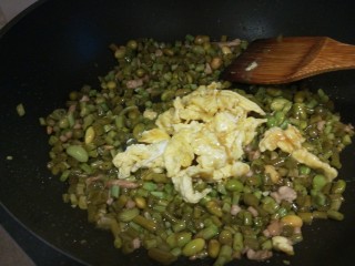 酸豆角炒鸡蛋,倒入鸡蛋，味精炒均匀即可。