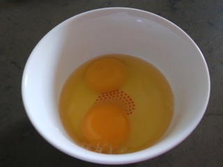 酸豆角炒鸡蛋,碗中打入两个鸡蛋搅拌均匀。